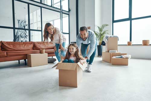 Famille s'amusant en préparant des cartons de déménagement